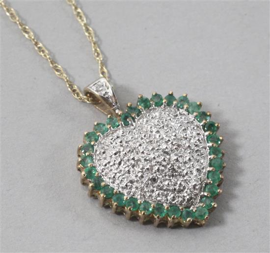 A 9ct gold, emerald and diamond set heart shaped pendant, on a 9ct gold fine link chain, pendant 27mm.